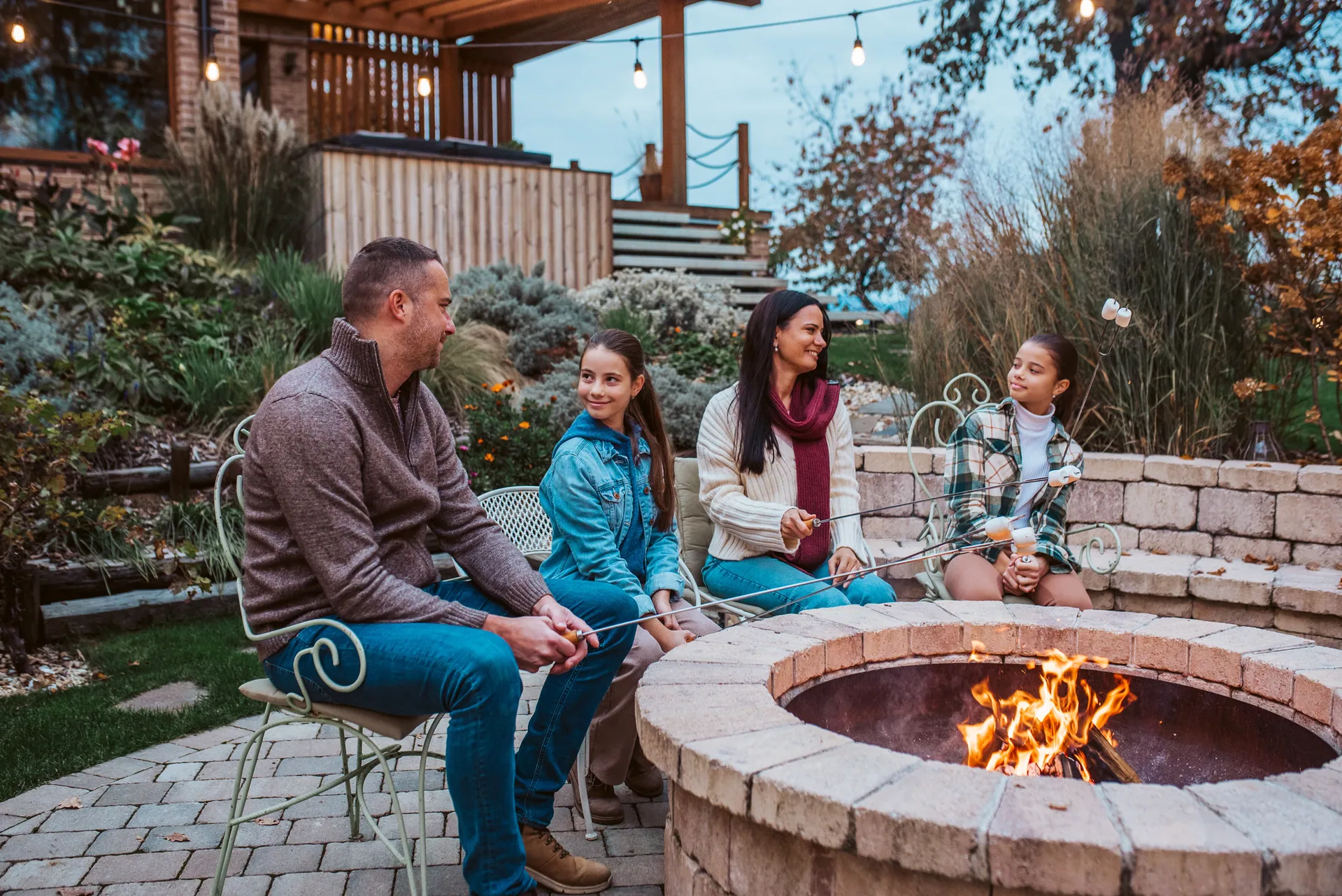Family around a brick paver fire pit in autumn