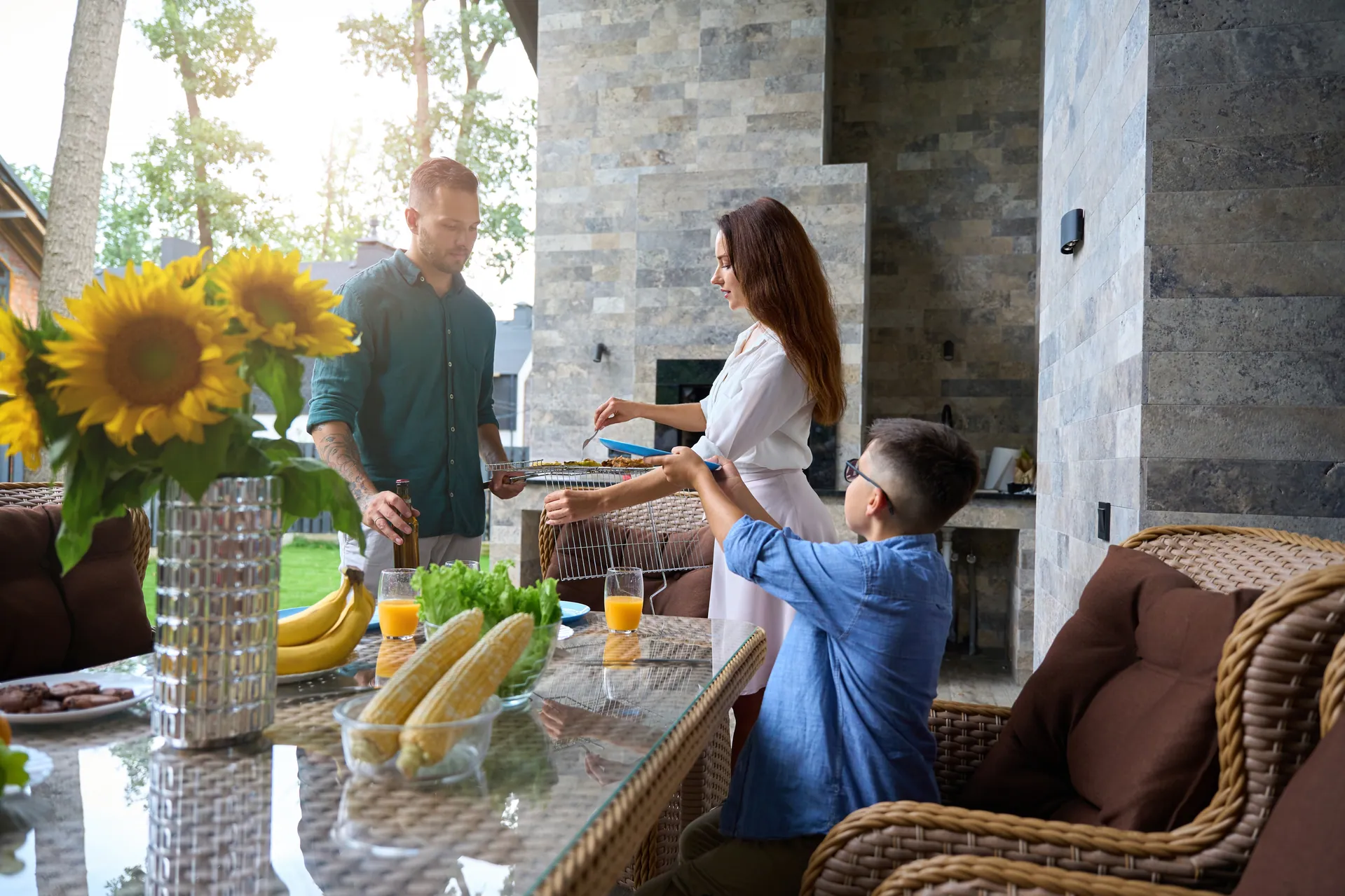 Family at an outdoor kitchen counter on a covered patio