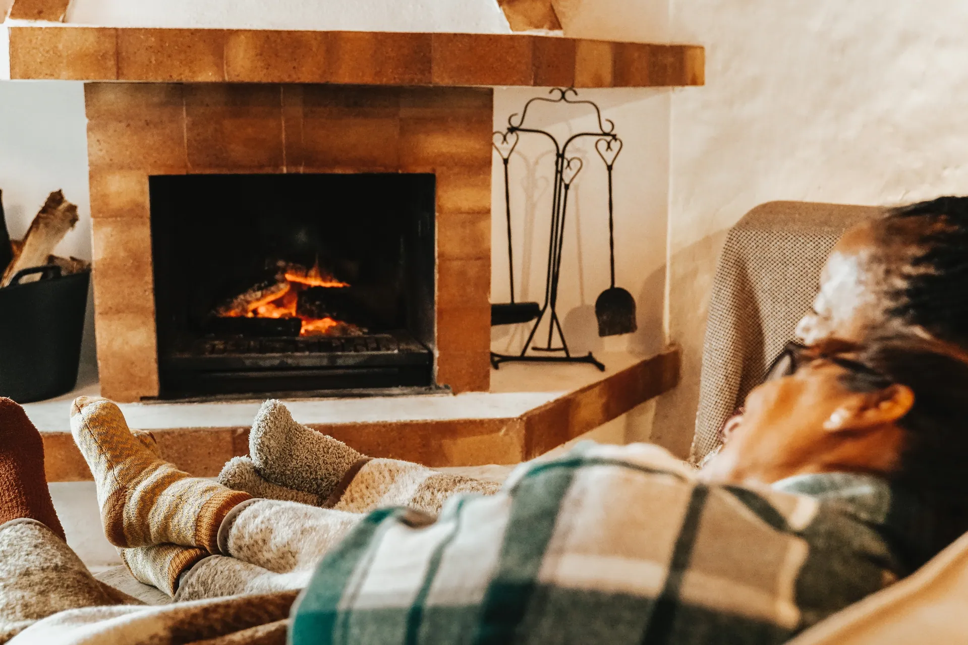 Traditional brick fireplace with someone resting under a blanket
